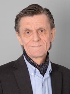 Professionelles GLKB-Porträt vor grauem Hintergrund.