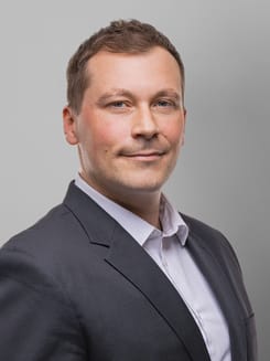 Professionelles GLKB-Porträt vor grauem Hintergrund.