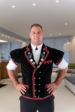 Glarner Schwinger Roger Rychen in traditioneller Kleidung mit Trachtenjacke steht selbstbewusst in der modernen Kundenzone der Glarner Kantonalbank.