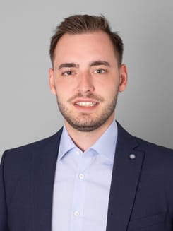 Professionelles GLKB-Porträt vor grauem Hintergrund.