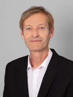 Professionelles GLKB-Porträt vor grauem Hintergrund.