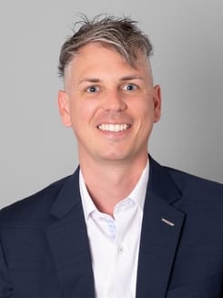 Professionelles GLKB-Porträt vor grauem Hintergrund.