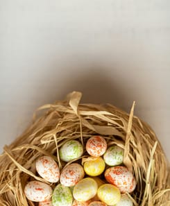 Bunte Ostereier in einem Nest aus Stroh als stimmungsvolles Frühlingsmotiv für Ostern und saisonale Inhalte.