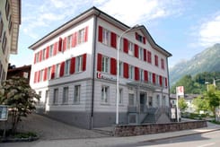 Gebäude der GLKB-Filiale Schwanden mit Blick auf die Berglandschaft.