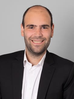 Professionelles GLKB-Porträt vor grauem Hintergrund.