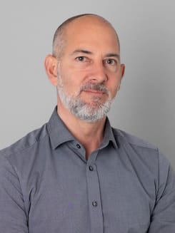 Professionelles GLKB-Porträt vor grauem Hintergrund.