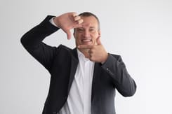 Professionelles Business-Porträt von Glarner Kantonalbank CEO Sven Wiederkehr mit kreativer Handgeste zur Visualisierung von Fokus und Perspektive.