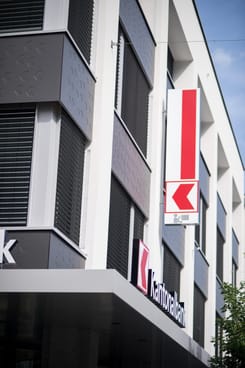 Aufnahme des GLKB-Hauptsitzes in Glarus mit beleuchteter Fassade und moderner Architektur.