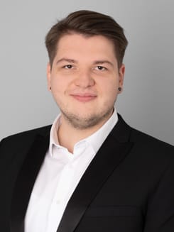 Professionelles GLKB-Porträt vor grauem Hintergrund.