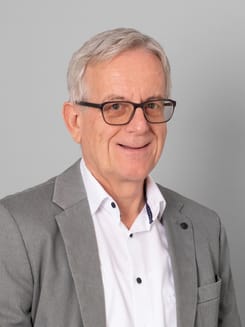 Professionelles GLKB-Porträt vor grauem Hintergrund.