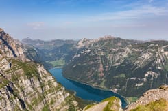 Panoramablick auf den Klöntalersee mit imposanten Bergen, steilen Felswänden und weiter Alpenlandschaft