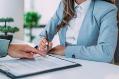 Lupe auf Vertragsunterlagen und Akten zur Prüfung von Dokumenten und rechtlichen Details.