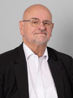 Professionelles GLKB-Porträt vor grauem Hintergrund.