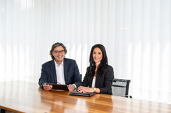 Rolf Hartmann, Leiter Handel/Tresorerie und Mitglied des GLKB EAM-/EVV-Teams, und Deborah Noser, Kundenberaterin Externe Vermögensverwalter (EAM) sitzen gemeinsam am Tisch im Besprechungsraum.