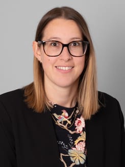 Professionelles GLKB-Porträt vor grauem Hintergrund.