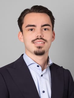 Professionelles GLKB-Porträt vor grauem Hintergrund.