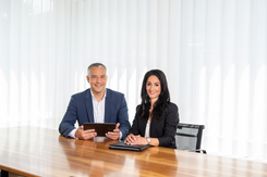 Lars Bernhard, Kundenberater External Asset Manager (EVV), und Deborah Noser, Kundenberaterin Externe Vermögensverwalter (EAM) sitzen gemeinsam am Tisch im Besprechungsraum.