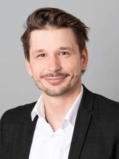 Professionelles GLKB-Porträt vor grauem Hintergrund.