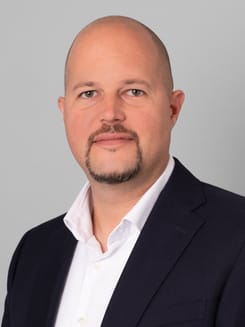 Professionelles GLKB-Porträt vor grauem Hintergrund.