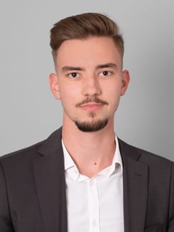 Professionelles GLKB-Porträt vor grauem Hintergrund.