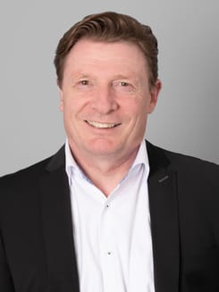 Professionelles GLKB-Porträt vor grauem Hintergrund.