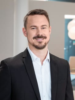 Professionelles GLKB-Porträt vor grauem Hintergrund.