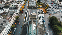 Luftaufnahme des Stadtzentrums von Glarus mit GLKB-Hauptsitz, Strassen und angrenzendem Parkplatz im Herbst.