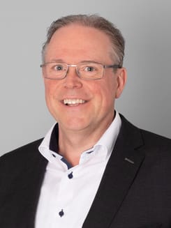 Professionelles GLKB-Porträt vor grauem Hintergrund.