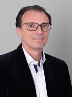 Professionelles GLKB-Porträt vor grauem Hintergrund.