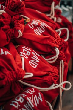 Stapelweise rote Turnbeutel für die Besucher:innen.