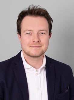 Professionelles GLKB-Porträt vor grauem Hintergrund.