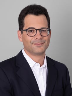 Professionelles GLKB-Porträt vor grauem Hintergrund.