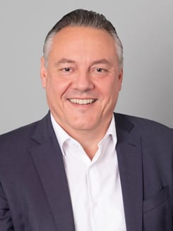 Professionelles GLKB-Porträt vor grauem Hintergrund.