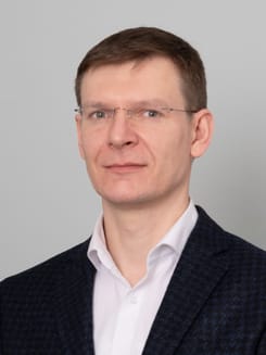 Professionelles GLKB-Porträt vor grauem Hintergrund.