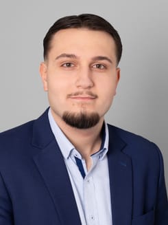 Professionelles GLKB-Porträt vor grauem Hintergrund.