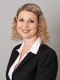 Professionelles GLKB-Porträt vor grauem Hintergrund.