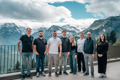 Mitarbeitende stehen gemeinsam vor einer alpinen Bergkulisse und symbolisieren Teamarbeit, Zusammenarbeit und Unternehmenskultur.