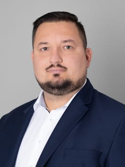 Professionelles GLKB-Porträt vor grauem Hintergrund.