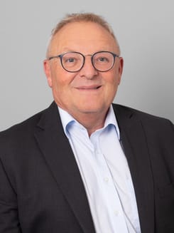 Professionelles GLKB-Porträt vor grauem Hintergrund.