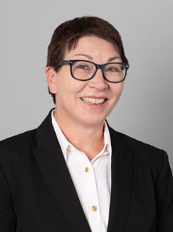 Professionelles GLKB-Porträt vor grauem Hintergrund.