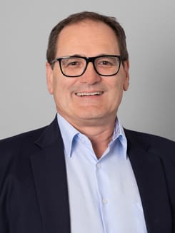 Professionelles GLKB-Porträt vor grauem Hintergrund.