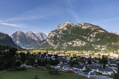 Panoramablick auf das Glarnerland mit markanten Bergen, historischer Kirche und eindrucksvoller Alpenkulisse
