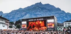 Sound of Glarus Konzertbühne bei Abendlicht mit Publikum und beeindruckender Alpenkulisse im Hintergrund.