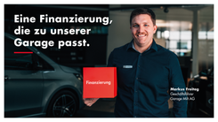 Geschäftsführer Markus Freitag in der Garage Milt AG mit roter Box zum Thema Finanzierung.