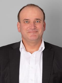 Professionelles GLKB-Porträt vor grauem Hintergrund.