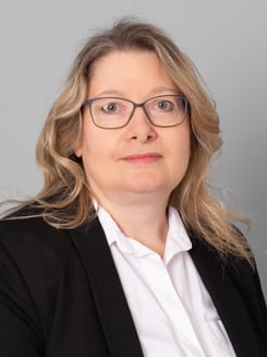 Professionelles GLKB-Porträt vor grauem Hintergrund.