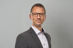 Professionelles GLKB-Porträt vor grauem Hintergrund.