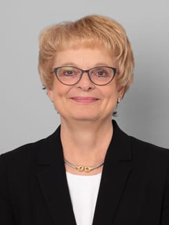 Professionelles GLKB-Porträt vor grauem Hintergrund.