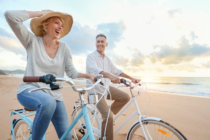 Paar mit Fahrrad am Strand