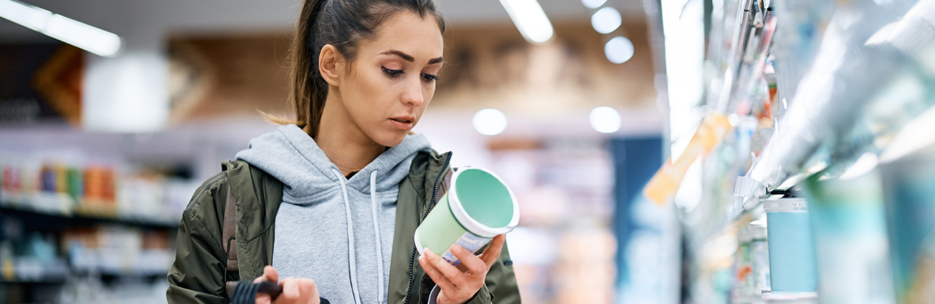 Frau beim Einkaufen mit Produkt in der Hand